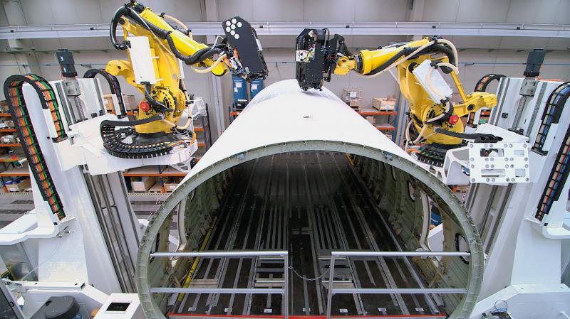 Zwei Industrieroboter, die bei der Montage von Flugzeugrümpfen Arbeitsschritte wie das Bohren und Nieten übernehmen. Diese Anwendung von Loxin 2002 wurde mit dem goldenen vector 2018 ausgezeichnet.