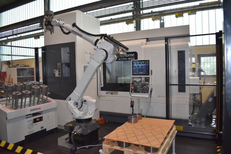 Vollautomatisiertes Fertigungssystem mit 6-Achs-Knickarmroboter und Komplettbearbeitungsmaschine Nakamura-Tome NTRX-300.